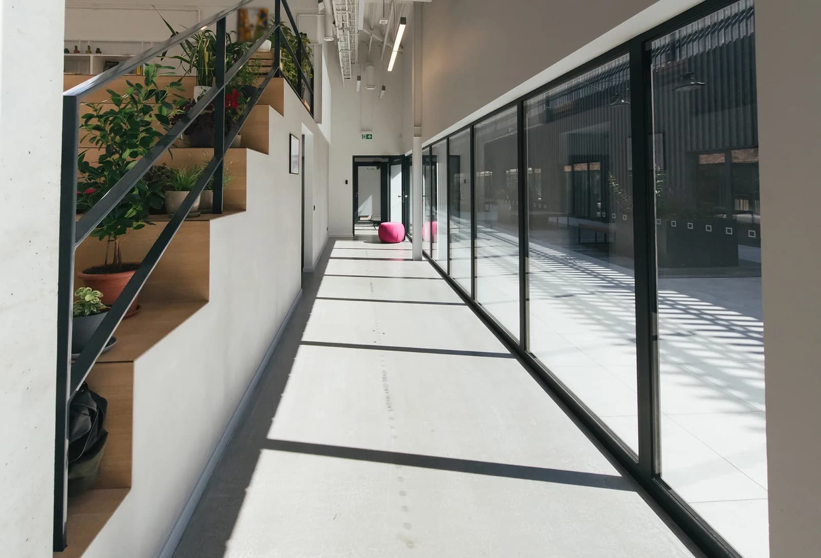 Daylit interior corridor framed by a full-height glazed wall