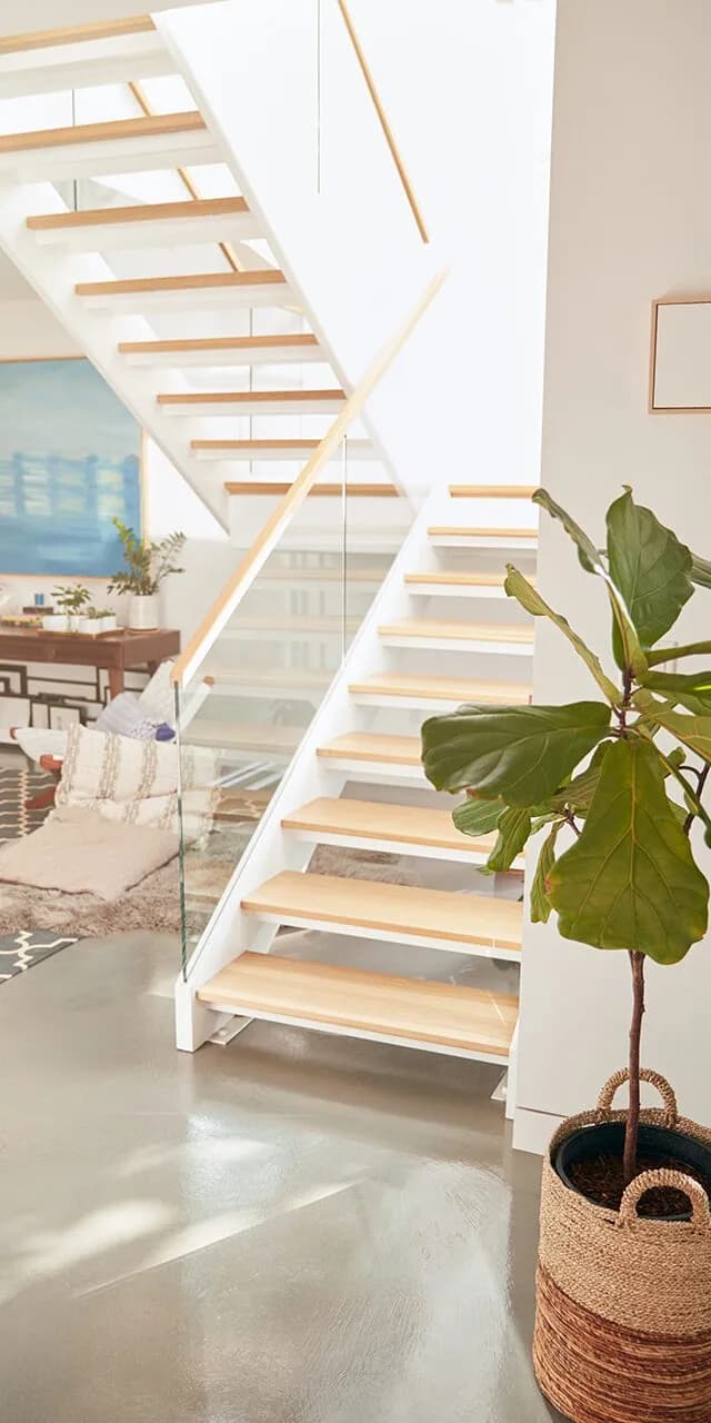 Beautiful living area with a glass staircase and soft furnishings in a new family home